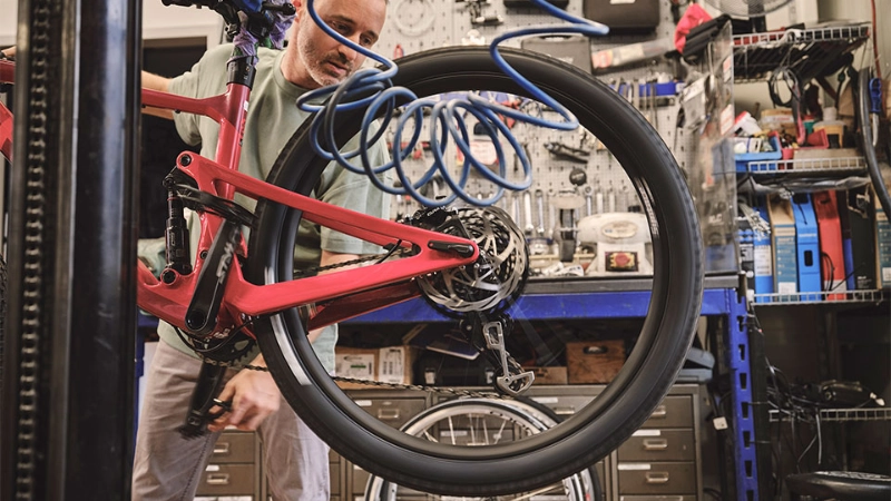 Ein Fachhändler überprüft den Reifendruck eines Fahrrads