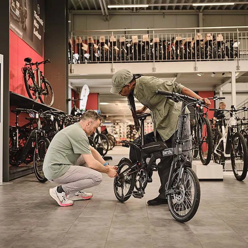 Ein Fachhändler berät eine Kundin mit Klapprad