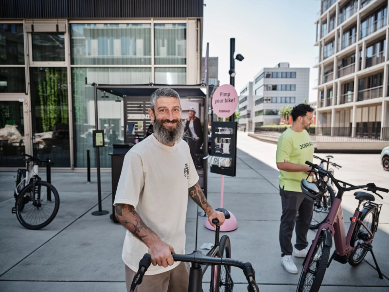 Mann schiebt Gravel und lächelt in die Kamera