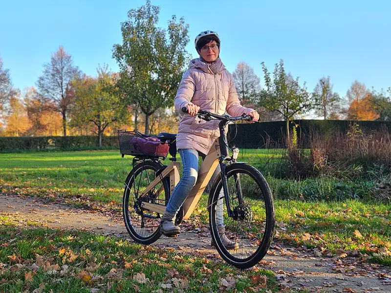Bettina Hentschel mit ihrem nachhaltigen Holz-Fahrrad bei sonnigem Herbstwetter auf einem Weg Bettina Hentschel mit ihrem nachhaltigen Holz-Fahrrad bei sonnigem Herbstwetter auf einem Weg